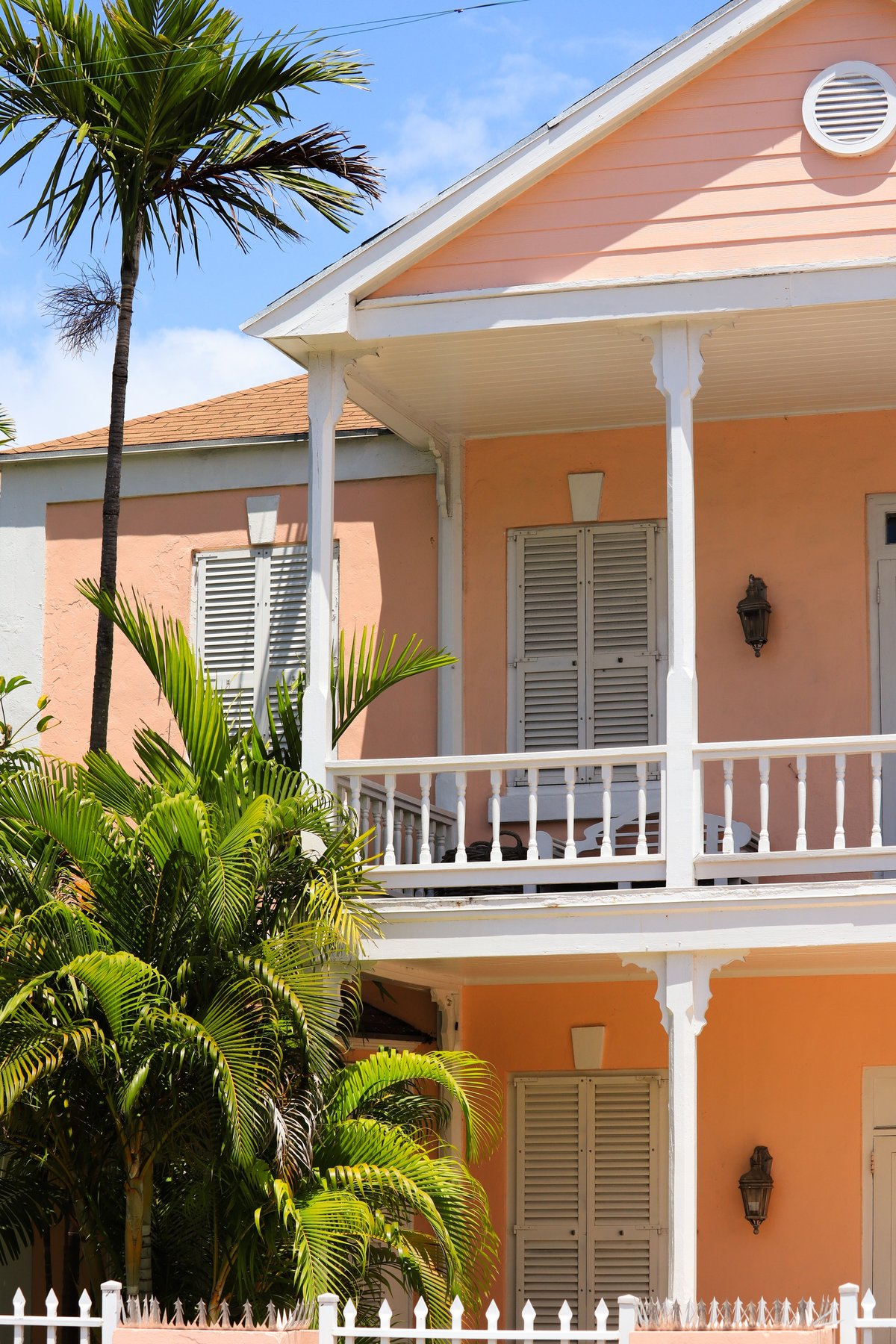 Traditional pastel-colored colonial-style Caribbean building with palm trees, reflecting Barbados architecture